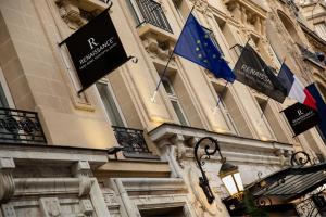 two flags are hanging on the side of a building at Renaissance Paris Nobel Tour Eiffel Hotel in Paris