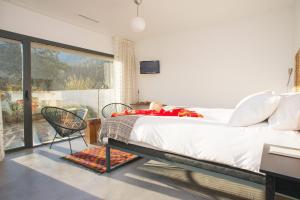 a bedroom with a large bed and a large window at El Hotelito in Navaluenga