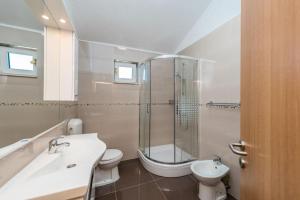 a bathroom with a shower and a toilet and a sink at Apartments Delfin with seaview 100 meters from the sea - by TA Leut Agency in Privlaka +82 photos