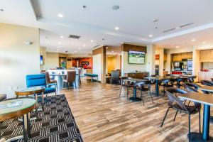 TownePlace Suites by Marriott Evansville Newburgh في Newburgh: مطعم بطاولات وكراسي وبار