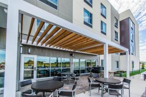 a patio with tables and chairs in a building at TownePlace Suites by Marriott Evansville Newburgh in Newburgh