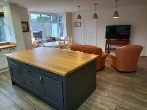 Ben Rhydding的住宿－Grange Croft，厨房以及带木制台面的客厅。