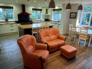 una cocina con 2 sillas de cuero y una isla de cocina en Grange Croft, en Ben Rhydding