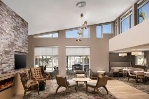 sala de estar con chimenea, mesa y sillas en Residence Inn by Marriott Tampa Wesley Chapel, en Wesley Chapel