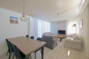 a living room with a table and a dining room at Familiehuis Noordenwind - Julianadorp aan Zee in Julianadorp