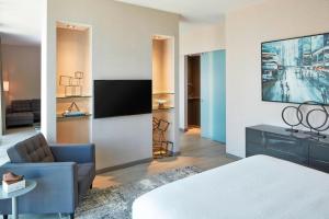 a hotel room with a bed and a tv at AC Hotel by Marriott Des Moines East Village in Des Moines
