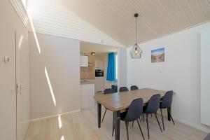 a dining room with a wooden table and chairs at Familiehuis Noordenwind - Julianadorp aan Zee in Julianadorp +27 photos