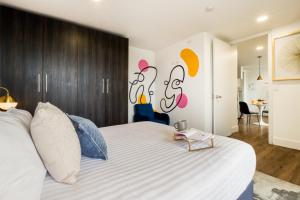 a bedroom with a large white bed with a table on it at ULIV Life Tijuana in Tijuana