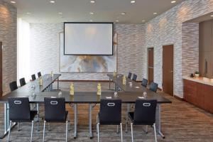 una sala conferenze con un lungo tavolo e sedie di AC Hotel by Marriott Des Moines East Village a Des Moines