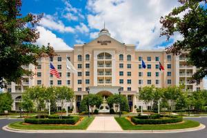 un gran edificio con banderas delante en The Ballantyne, a Luxury Collection Hotel, Charlotte en Charlotte