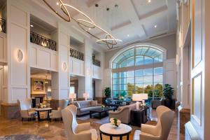 a lobby with couches and chairs and a large window at The Ballantyne, a Luxury Collection Hotel, Charlotte in Charlotte