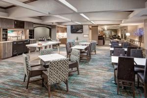 a dining room with tables and chairs and a kitchen at Residence Inn Kansas City Country Club Plaza in Kansas City