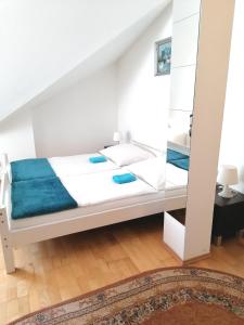 um quarto com uma cama branca e lençóis azuis em Favoriten-Rooms em Viena