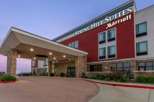 a building with a sign that reads synergy suites marriott at SpringHill Suites by Marriott Enid in Enid