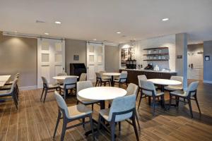 un restaurante con mesas y sillas y una cocina en Residence Inn Middletown Goshen, en Middletown