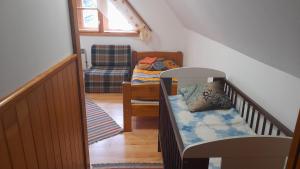 Zimmer mit einer Treppe mit einem Kinderbett und einem Stuhl in der Unterkunft Chalupa pod Skleným Vŕškom in Huty