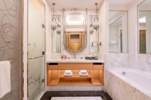 een badkamer met een bad en een wastafel bij The St. Regis Doha in Doha