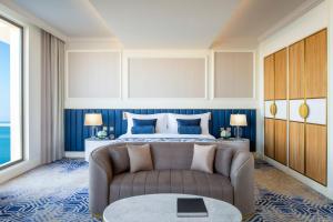 um quarto de hotel com uma cama e um sofá em The St. Regis Doha em Doha