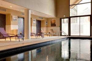 - une piscine avec des chaises dans un bâtiment dans l'établissement Renaissance Aix-en-Provence Hotel, à Aix-en-Provence