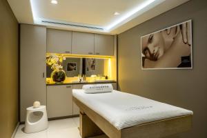 um pequeno quarto com uma cama e um lavatório em Renaissance Aix-en-Provence Hotel em Aix-en-Provence
