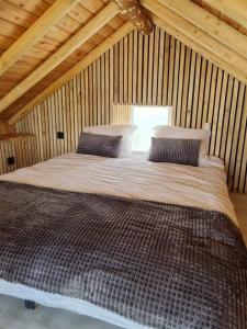 een slaapkamer met een groot bed in een houten hut bij Ô ptit Zébo in Bras