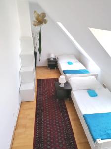 2 Betten in einem Zimmer mit einem roten Teppich in der Unterkunft Favoriten-Rooms in Wien