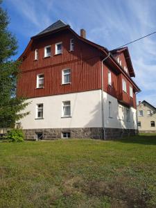 a large red and white house with a red roof at OK FERIEN - Altes Bahnhaus in Muldenhammer