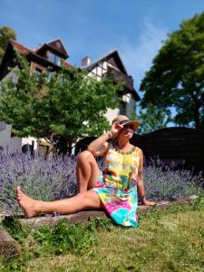 kobieta w kolorowej sukience siedząca na trawie w obiekcie Willa Kwiaty Polskie w Jedlinie-Zdroju