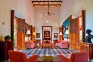 - un salon avec des chaises roses et une table dans l'établissement Hacienda Temozon, à Abalá