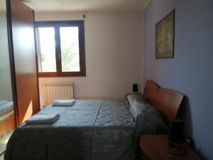 1 dormitorio con cama, mesa y ventana en A casa di Rita, en Surbo