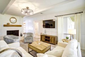 a living room with white furniture and a fireplace at Quiet Conroe Getaway with Patio, Golf Views! in Conroe