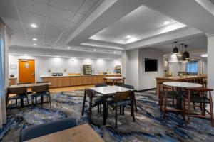 a waiting room with tables and chairs and a counter at Fairfield Inn & Suites Elizabeth City in Elizabeth City