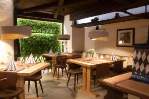 a restaurant with wooden tables and chairs and a green wall at Hotel Stadtkrug in Weiden