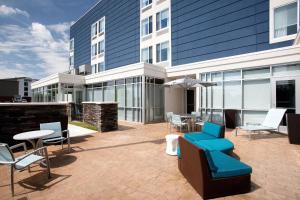 a patio with chairs and tables in front of a building at SpringHill Suites by Marriott Murray in Murray