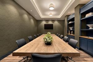 a conference room with a wooden table and chairs at Cotton House, Cleveland, a Tribute Portfolio Hotel in Cleveland