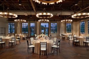 a banquet hall with tables and chairs and chandeliers at Cotton House, Cleveland, a Tribute Portfolio Hotel in Cleveland