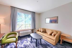 Fairfield Inn & Suites by Marriott Dallas Cedar Hill في سيدار هيل: غرفة معيشة مع أريكة وطاولة ونافذة