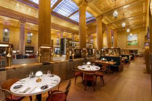 uma sala de jantar com mesas e cadeiras num edifício em The National, Autograph Collection em Oklahoma City