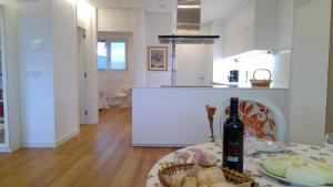 cocina con mesa y botella de vino en Preciosa Habitación Doble en Ático con Terraza II, en Santiago de Compostela