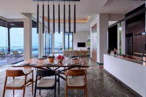 jadalnia i kuchnia ze stołem i krzesłami w obiekcie Renaissance Bali Uluwatu Resort & Spa w mieście Uluwatu