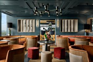 un restaurant avec des tables et des chaises ainsi qu'un bar dans l'établissement AC Hotel by Marriott Bella Sky Copenhagen, à Copenhague