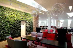 ein Restaurant mit roten Stühlen und einer grünen Wand in der Unterkunft AC Hotel by Marriott Bella Sky Copenhagen in Kopenhagen