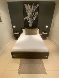 uma cama num quarto com duas lâmpadas em duas mesas em 608 Beacon Rock em Durban