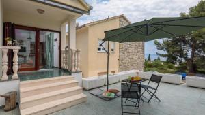 a patio with a table and a green umbrella at "NM" Luxury apartments in Split