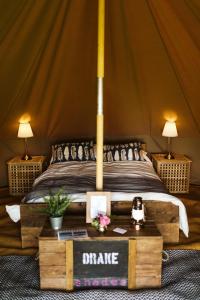 Gaggle of Geese Pub - Shepherd Huts & Bell Tents في دورتشستر: غرفة نوم بسرير في خيمة