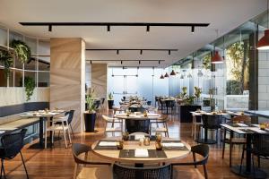 a restaurant with tables and chairs and windows at Courtyard by Marriott Sydney-North Ryde in Sydney