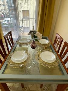 a glass table with plates and glasses on it at Sea Life Salou Apartment in Salou