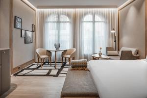 馬德里的住宿－圈大街傲途格精選酒店（僅限成人入住），酒店客房带一张床、一张桌子和椅子