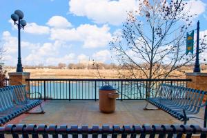 two benches sitting next to a fence with a tree at SpringHill Suites by Marriott Lawrence Downtown in Lawrence