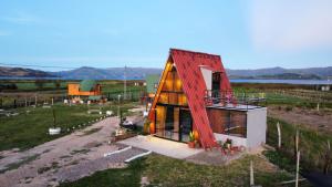 a small house with a red roof on top of it at Glamping y Cabañas el Encanto-Girasoles in Tota
